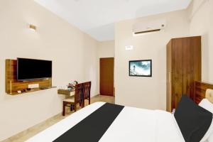 a bedroom with a bed and a tv on the wall at Super Collection O Virajpet City Centre formerly The Fort Mercara in Madikeri +32 photos