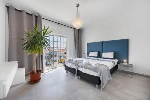 a bedroom with a large bed and a potted plant at Casa Surfer’s Sanctuary - Algarve in Vila do Bispo +21 photos