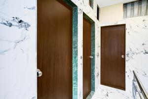 a wooden door in a room with a marble wall at Hotel O Khar East Near Railway Station in Mumbai