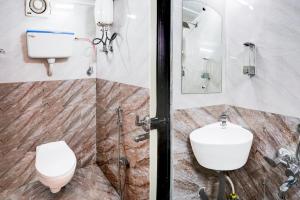 a bathroom with a toilet and a sink at Hotel O Khar East Near Railway Station in Mumbai