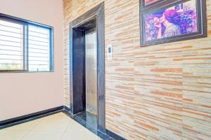 a wooden wall with a glass door in a room at Collection O Surathkal Beach Formerly Coastal Lodge in Suratakal