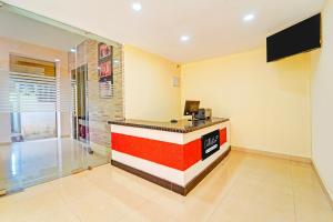 a lobby with a red and white reception desk at Collection O Surathkal Beach Formerly Coastal Lodge in Suratakal