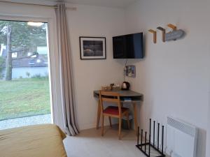 a bedroom with a desk and a tv on the wall at Chambre à Bangor in Bangor +16 photos