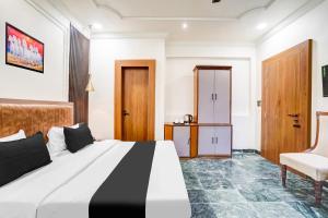 a hotel room with a bed and a chair at OYO Collection O Ratan Lal Nagar in Kānpur