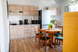 a kitchen with a table and chairs and a refrigerator at Na Krótkiej in Złoty Stok +11 photos