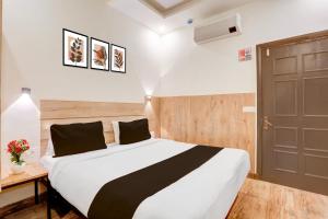 a bedroom with a large bed and a door at Townhouse Jagatpura Downtown Formerly Hotel Buddhi in Jaipur