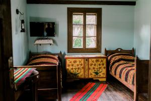 a bedroom with two beds and a window at Starodawna Chata - Baba in Zamość