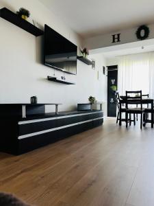 a living room with a table and a tv on the wall at Otopeni Airport Apartment - Free Shuttle Included in Otopeni +4 photos