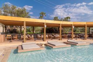 a pool with tables and chairs and a pavilion at SENTIDO Apollo Palace in Mesongi +65 photos