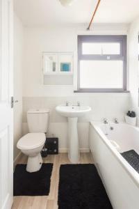 une salle de bain blanche avec toilettes et lavabo dans l'établissement Central Cornwall Stay, à Redruth