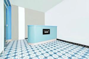 a room with a blue wall and a checkered floor at Super Townhouse Oak Kompally in Hyderabad