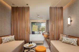 a living room with a couch and a bed and a window at SENTIDO Apollo Palace in Mesongi