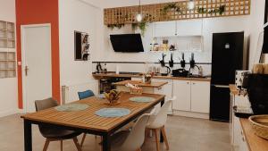 een keuken met een houten tafel en stoelen bij La maison d'Angelique - Coliving Hotel - Gare de Niort in Niort