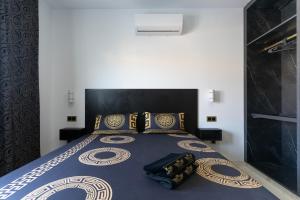 a bedroom with a bed with a blue comforter and pillows at HH Riz Resort - Adults Only in Maspalomas
