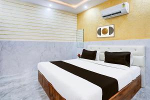 um quarto com uma grande cama branca em um quarto em Super Hotel O Mall Road Gwalior formerly Rama inn em Gwalior mais 24 fotografias