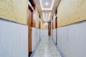 um corredor com paredes brancas e um corredor com um corredor longo em Super Hotel O Mall Road Gwalior formerly Rama inn em Gwalior