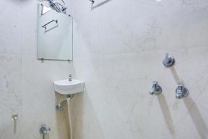 um banheiro com uma pia e um espelho na parede em Super Hotel O Mall Road Gwalior formerly Rama inn em Gwalior