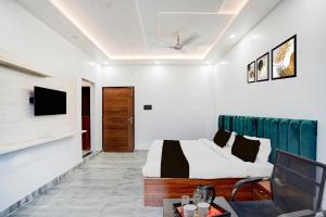 a bedroom with a bed and a tv on a wall at Super Hotel O Hanuman Gadi Formerly Alankar Lawn in Varanasi