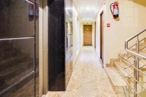 a hallway with stairs and a black door at Townhouse Oak Kodambakkam Formerly Cine City in Chennai +53 photos
