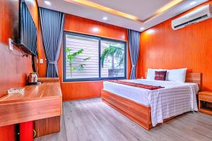 a bedroom with a bed and a desk and a television at S79 Phu Van Aires Beach Bungalow in Phu Quoc