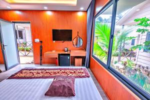 a room with a bed and a desk and a tv at S79 Phu Van Aires Beach Bungalow in Phu Quoc
