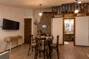 a living room with a table and chairs and a television at Casa Masovera in Linares de Mora