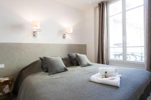 カンヌにあるAppartement design proche Croisette, classé 4 étoilesのベッドルーム1室(タオル付きのベッド1台付)