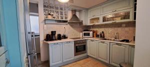 a kitchen with white cabinets and a microwave at Syra & Hermes Home in Ermoupoli +46 photos