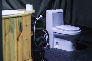 Un baño con inodoro en una tienda de campaña negra. en Daga Tented Camp, en Mikumi