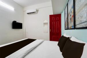 a bedroom with a bed and a red door at Super Hotel O Palarivattom Metro Station Formerly South Gate in Edappally +21 photos