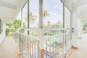 a room with large windows and a balcony with palm trees at Super Collection O Valiyavila Junction Formerly Prism Heights in Trivandrum