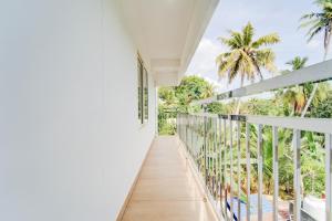 a balcony with a view of the palm trees at Super Collection O Valiyavila Junction Formerly Prism Heights in Trivandrum