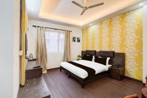 Super Townhouse Sector 51 Noida Near Metro Station في نويدا: غرفة نوم بسرير وجدار اصفر