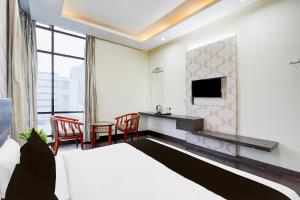 Super Townhouse Sector 51 Noida Near Metro Station في نويدا: غرفة فندق مع سرير وتلفزيون