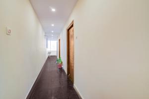 an empty hallway with a door and a potted plant at Hotel O Neredmet Road in Hyderabad
