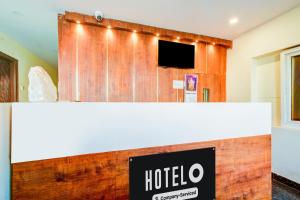 a hotel room with a wooden wall with a tv at Hotel O Neredmet Road in Hyderabad