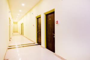 an empty corridor with two doors in a building at Super Collection O Howrah Botanical Garden Formerly Tanima Villa in Sāntrāgāchi