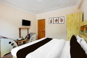 a bedroom with a white bed and a television at Hotel O Aleo Near Mall Road Formerly Aman Cottage in Manāli +23 photos