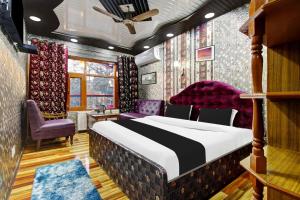 a bedroom with a large bed and purple chairs at Super Hotel O Residency Road Srinagar in Srinagar +38 photos