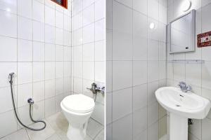 a white bathroom with a toilet and a sink at Super Hotel O Residency Road Srinagar in Srinagar