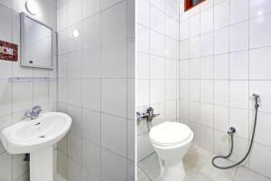 a white bathroom with a toilet and a sink at Super Hotel O Residency Road Srinagar in Srinagar