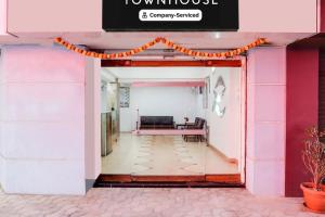 a hallway of a pink and white building with a bench at Townhouse Margao Near Railway Station Formerly Hotel Tanish in Goa