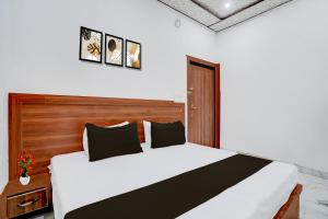 アグラにあるHotel O Sikandra Near ISBT Agraの木製のヘッドボードが付いた白いベッドのある寝室 +28枚の写真