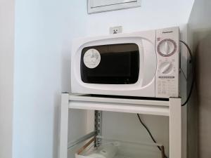 a microwave sitting on a shelf in a room at Fanhua Life IN Nanjing West Road Store 2 in Shanghai