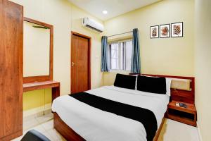 a bedroom with a bed and a window at Super Collection O Vadapalani Metro Station Formerly Pineapple Guest House in Chennai