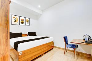 una camera da letto con un letto, un tavolo e una scrivania di Collection O Sector 62 Faridabad a Ballabgarh