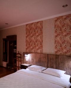 Un dormitorio con una cama grande con cabecero de madera. en Omar Khayyam Hotel, en Bukhara