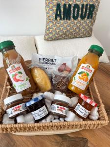 a basket of food and condiments on a couch at Studio La belle étape in Bretenoux +7 photos