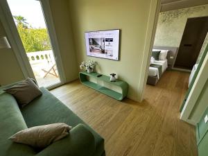 a living room with a green couch and a table at B&B Villa Margherita - Luxury Rooms in Padua in Padova