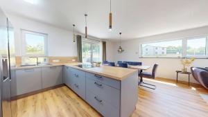 a kitchen with white cabinets and a dining room with a table at Sandäcker30 in Kaiserslautern